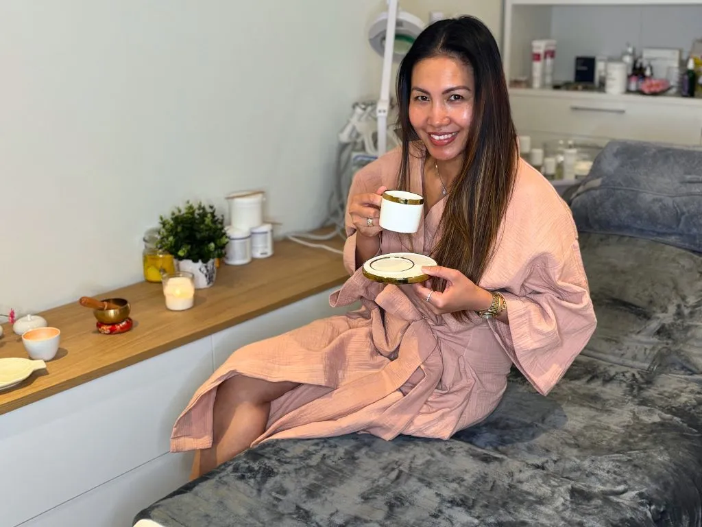 Portrait d'une cliente souriante qui boit un thé après son massage